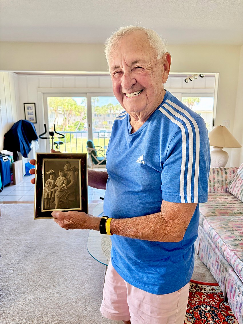 Harold Goldstein holds up a photo of himself as a child.