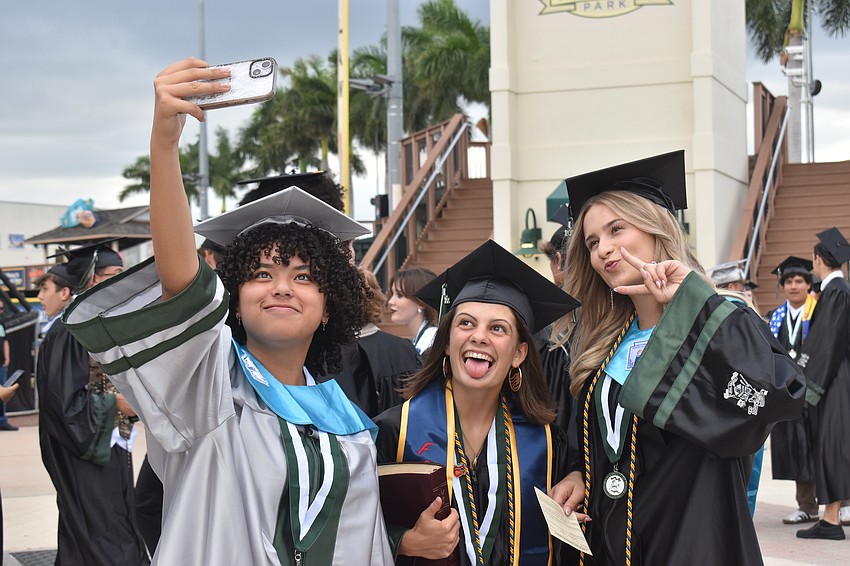 Isabelle Mayo, Collete Testa and Emma Syfert capture a moment before they walk LECOM Park to receive their diplomas.