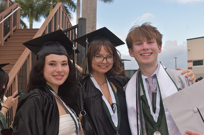 Sydney MacCalmon, Gabriella Caraher and Jack Lowrance prepare to walk the field at Lecom Park to graduate from Lakewood Ranch High School.