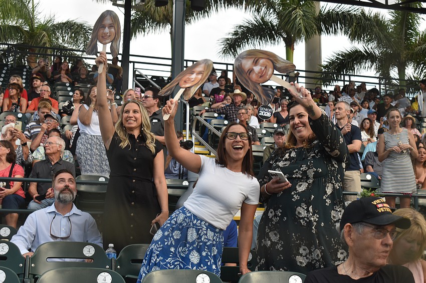 Danielle Syfert, Nicole Santiago and Christine Moore want to make clear who they are here to support. This meant making copies of Lakewood Ranch High School graduate Emma Syfert's face to cheer her on.