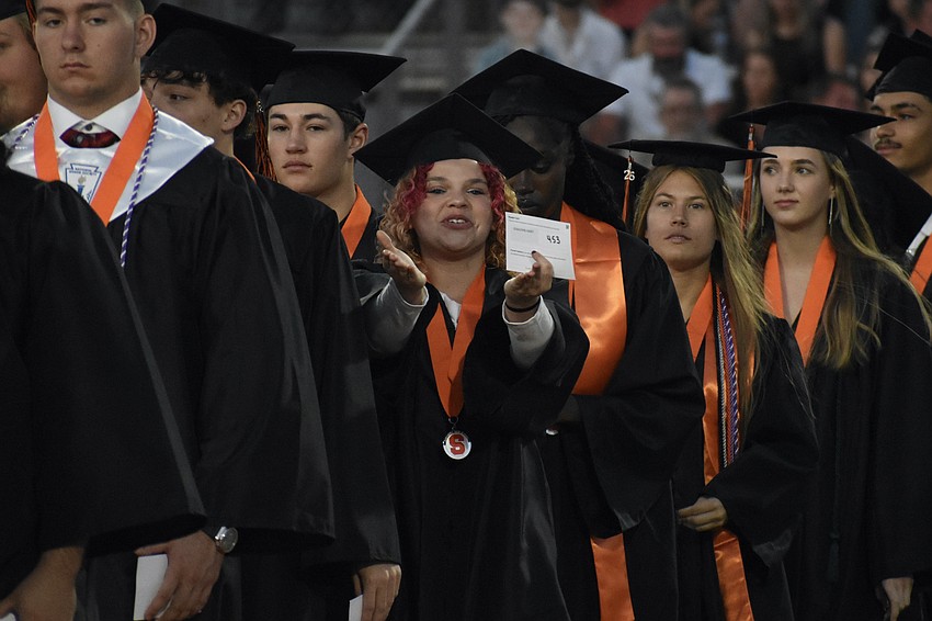Kasey Stancomb blows a kiss towards the crowd as students head onto the field.