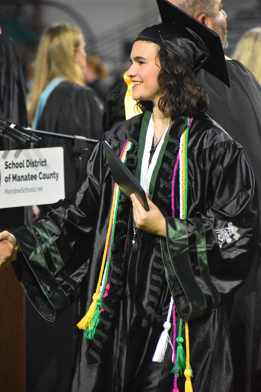 Genevieve Sammons, who was colorguard captain and a member of band and choir, receives her diploma.