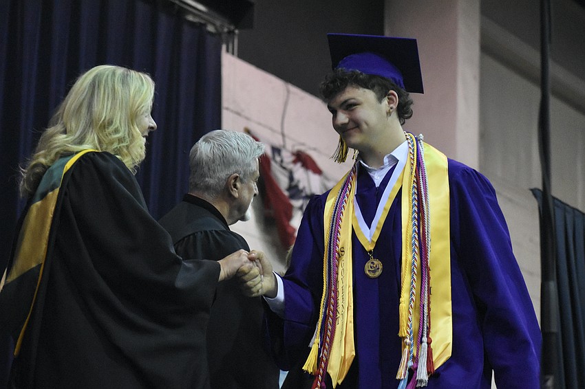 Cooper Nielson greets school board member Liz Barker.