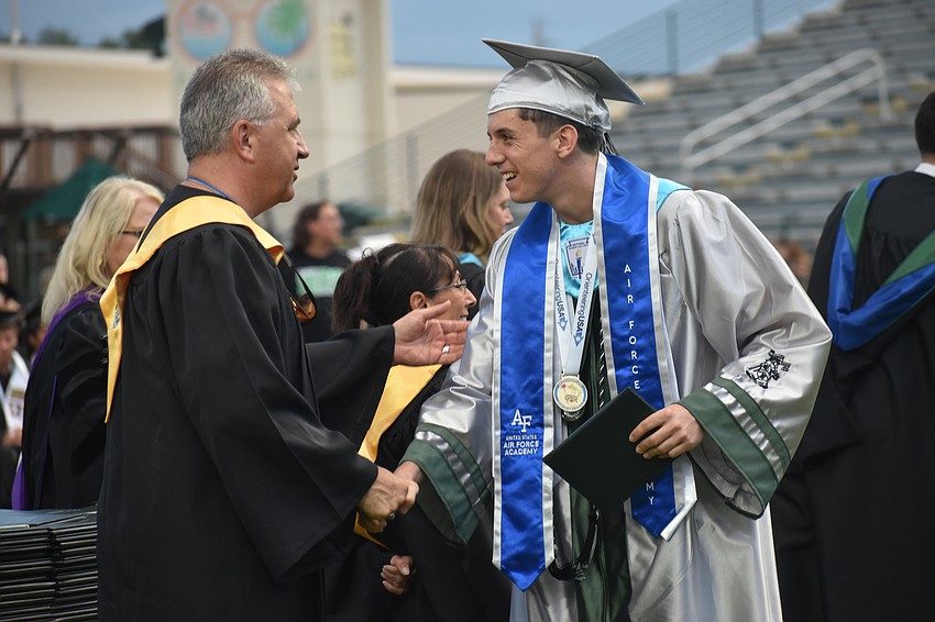 Richard Tatem, vice chair of the school board and a veteran, congratulates Jack Crosbie on graduating and being accepted into the United States Air Force Academy.