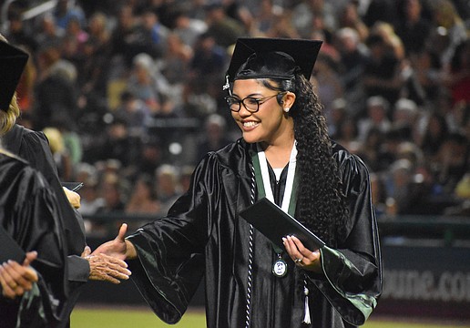 Sophia Wiley makes her way down the row to shake hands after she receives her Lakewood Ranch High School diploma at Lecom Park May 18.