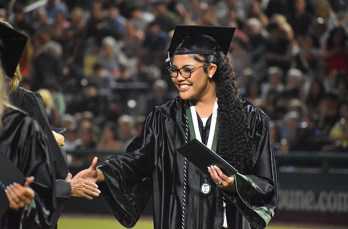 Sophia Wiley makes her way down the row to shake hands after she receives her Lakewood Ranch High School diploma at Lecom Park May 18.
