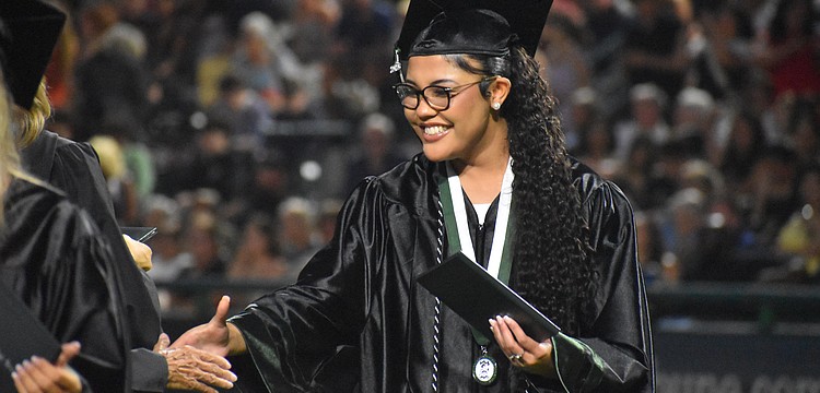 Sophia Wiley makes her way down the row to shake hands after she receives her Lakewood Ranch High School diploma at Lecom Park May 18.