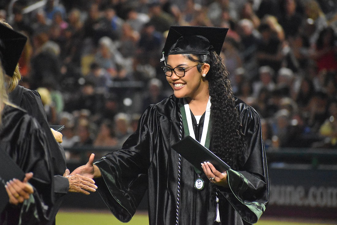Sophia Wiley makes her way down the row to shake hands after she receives her Lakewood Ranch High School diploma at Lecom Park May 18.