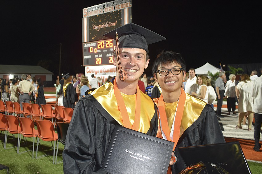 Bryce Canfield and Saharat Suwongjun celebrate graduating.