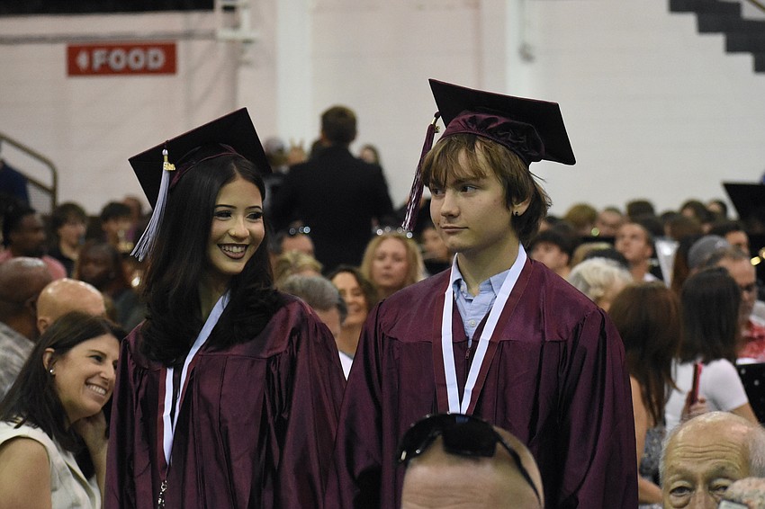 Genesis Colon and Caleb Cox get ready to graduate as they head to their seats.