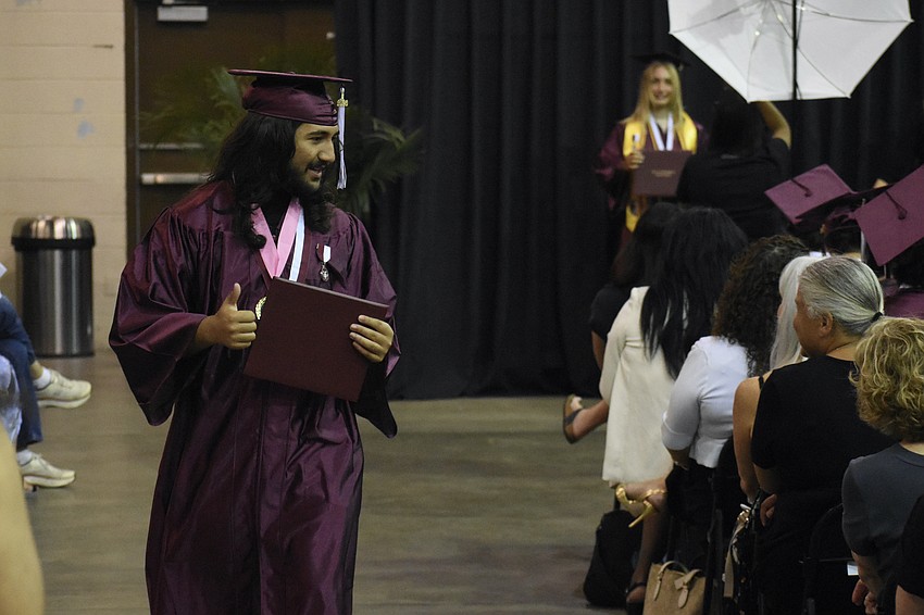Michael Smallwood II returns to his seat with a diploma in hand.