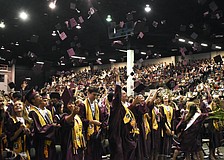 Students toss their caps as the status of graduation is conferred.