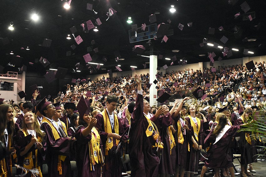 Students toss their caps as the status of graduation is conferred.