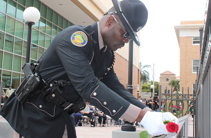 Florida Highway Patrol Trooper Michelson Fleurant places a rose on a plaque at the Manatee County Law Enforcement Memorial Service May 14 in Bradenton.