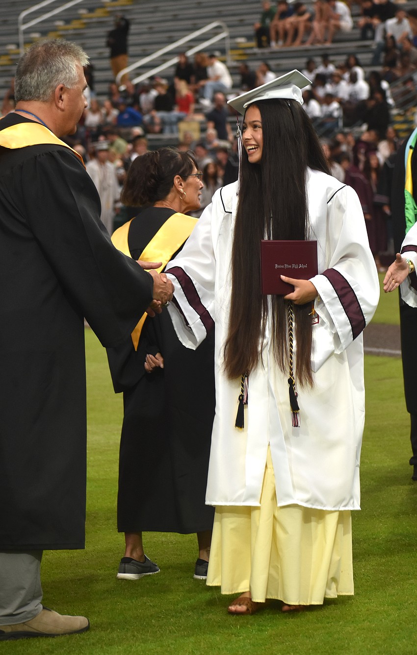 Vice Chair Richard Tatem congratulates Kaiya Peters, a member of JROTC and one of the commencement speakers, for graduating.