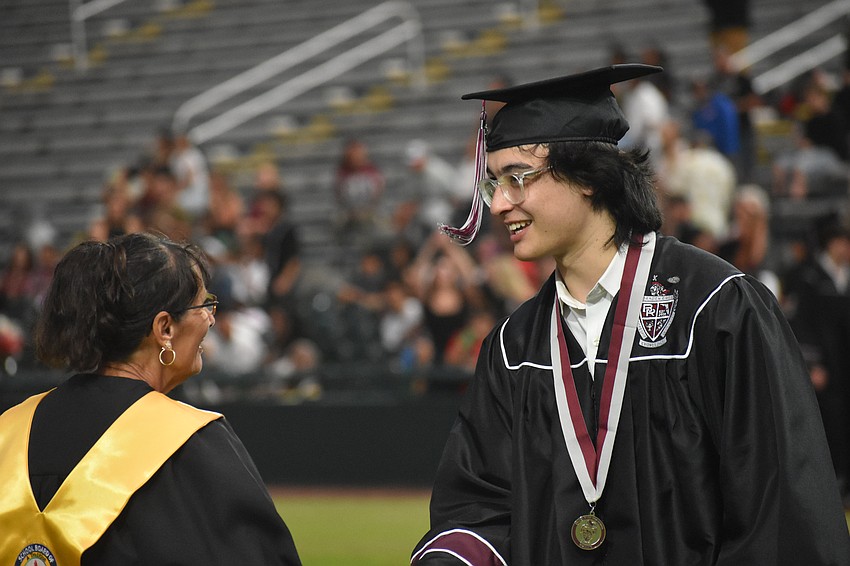 Cindy Spray, chair of the school board, congratulates John Franco at the Braden River High commencement May 19 at LECOM Park.