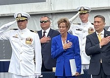 Robyn Modly, sponsor of the USS Cleveland, takes in the Navy band’s performance of the “Star Spangled Banner” aside Bruce Hallet, left, commander of the USS Cleveland, and Hung Cao, acting secretary of the Navy.