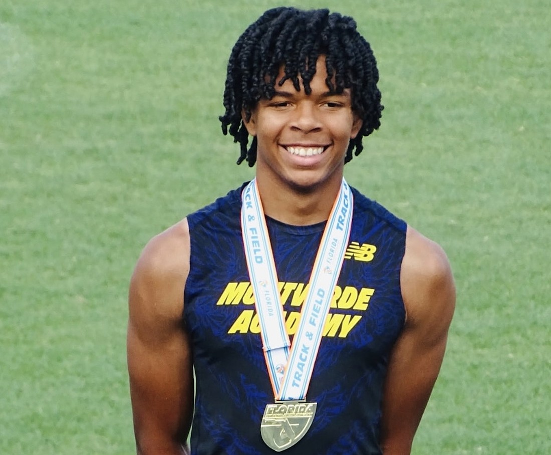 Grant Williams proudly stood with his pole-vaulting state championship medal.