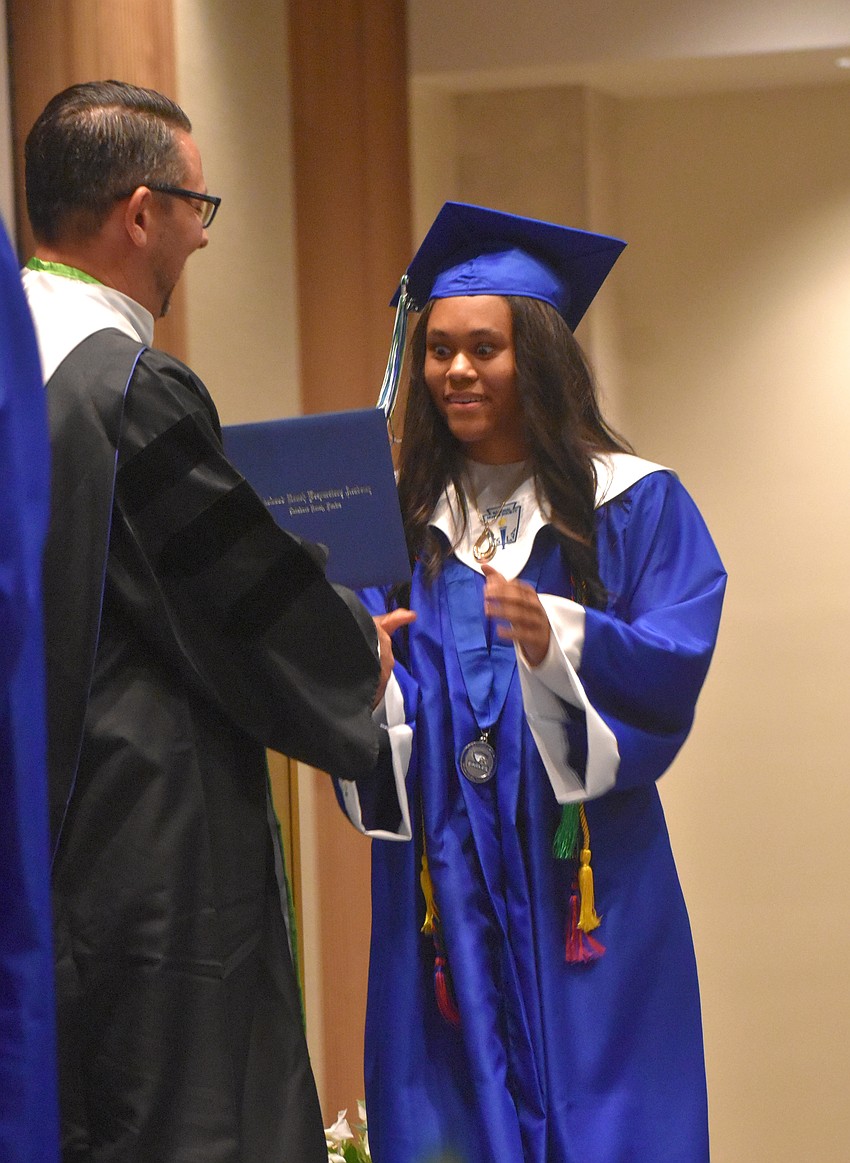 Head of School Chad McBane presents Eliana Yeboah, who gave a speech at graduation, her diploma.