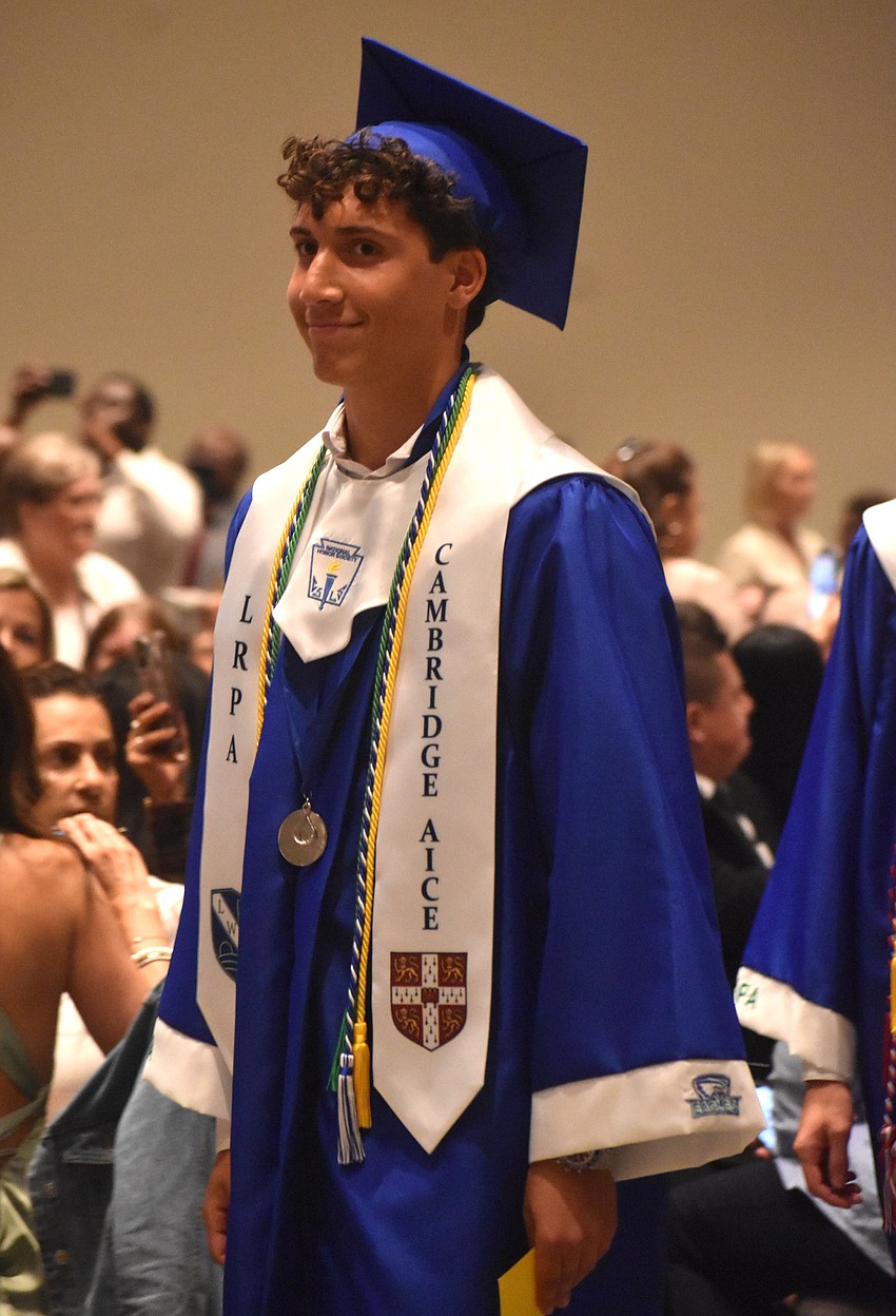 Andrew Cordani, who earned the Cambridge Advanced International Certificate of Education diploma, heads to his seat as the Lakewood Ranch Preparatory Academy commencement begins.