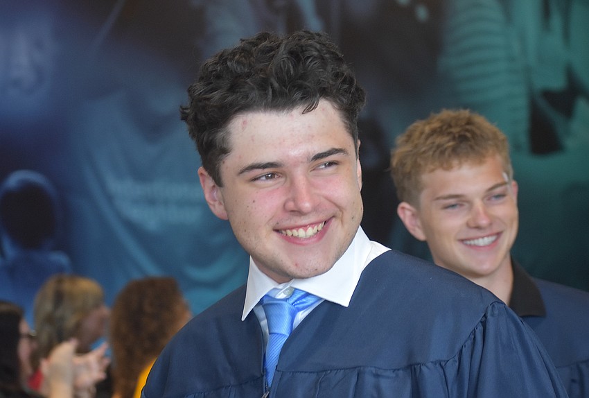 Graduates Christoph Chidichimo and Caleb Cheney make their way through the tunnel of educators from The Out-of-Door Academy May 22.