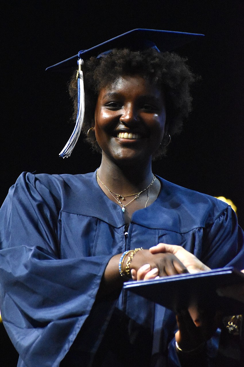 Milion Knego, a graduate of the Out-of-Door Academy, beams with pride as she receives her high school diploma May 22 at Grace Community Church.