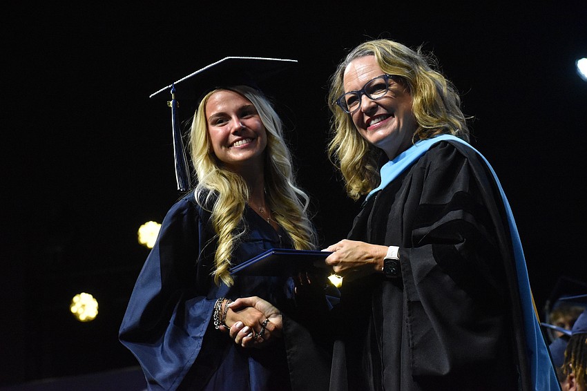 Emerson Miller gets the graduate handshake from Head of School Debra Otey at The Out-of-Door Academy commencement ceremony.