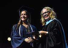 Oceane Visa, who says she has waited years to walk across the stage for graduation, is congratulated by Head of School Debra Otey.