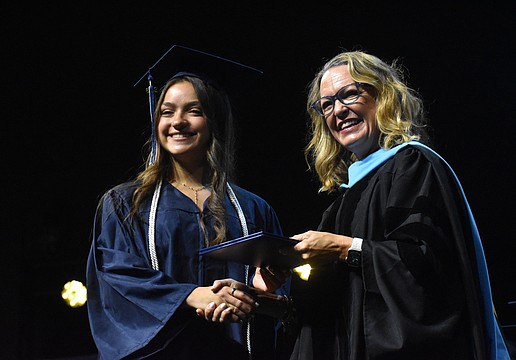 Oceane Visa, who says she has waited years to walk across the stage for graduation, is congratulated by Head of School Debra Otey.