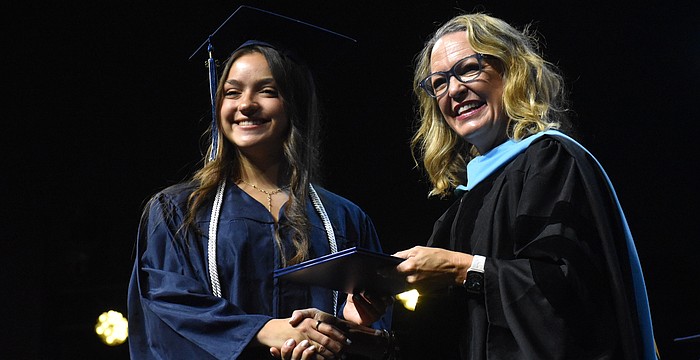 Oceane Visa, who says she has waited years to walk across the stage for graduation, is congratulated by Head of School Debra Otey.