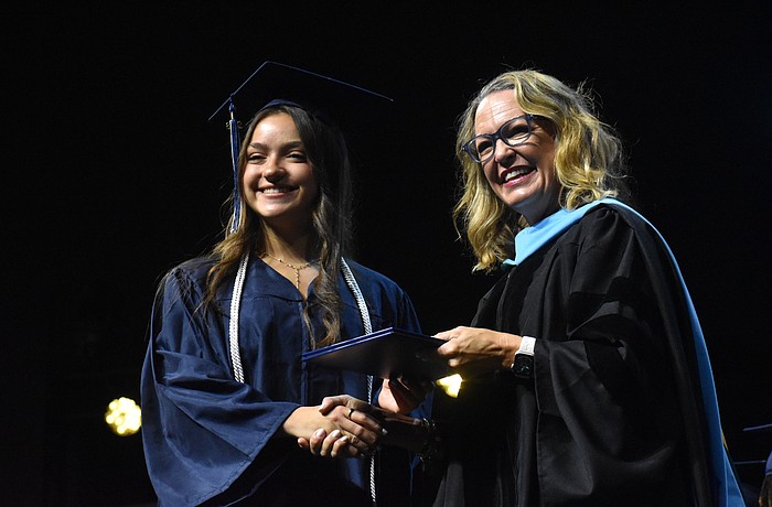 Oceane Visa, who says she has waited years to walk across the stage for graduation, is congratulated by Head of School Debra Otey.