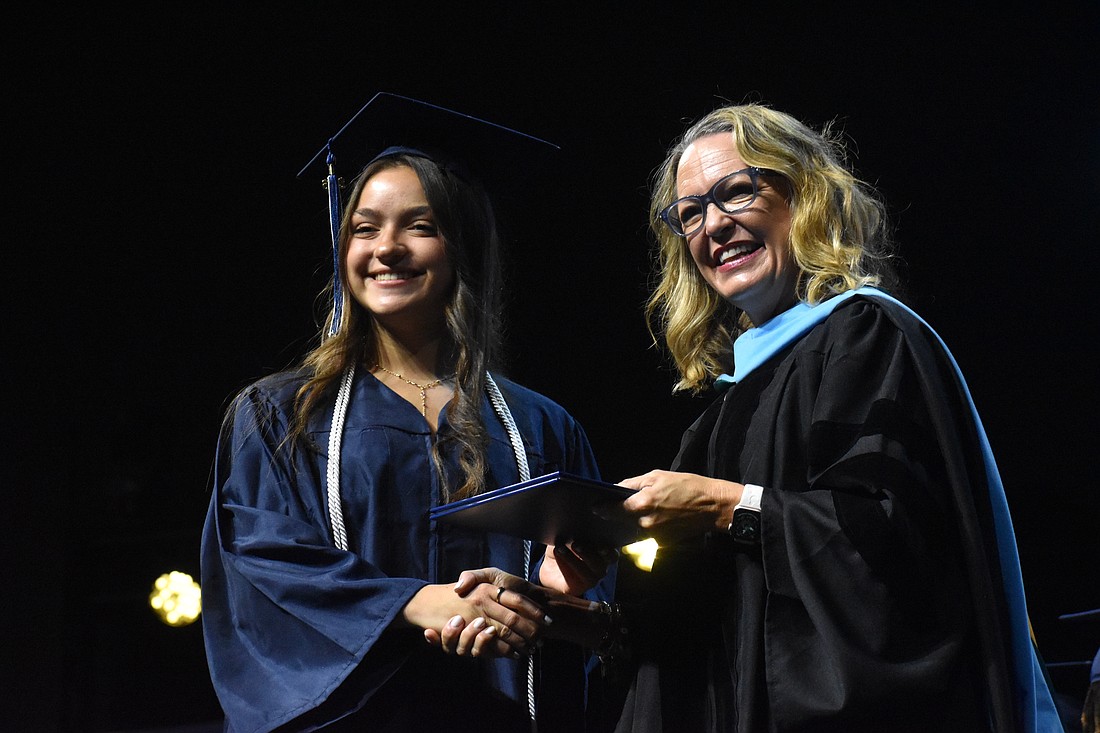 Oceane Visa, who says she has waited years to walk across the stage for graduation, is congratulated by Head of School Debra Otey.