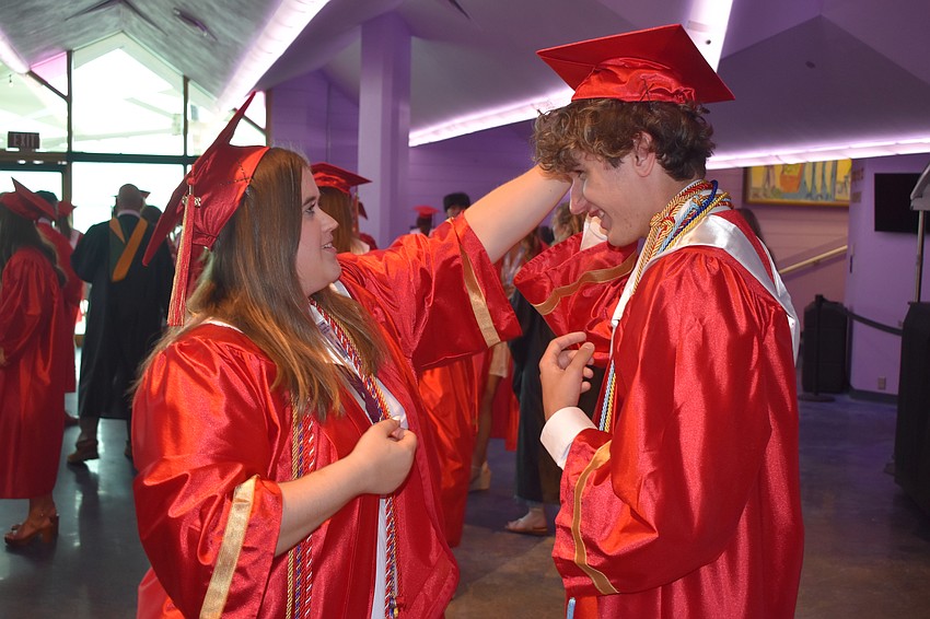 Erin Griffith adjusts the cap of her friend Gabe Mehlum, who gave the salutatorian address.