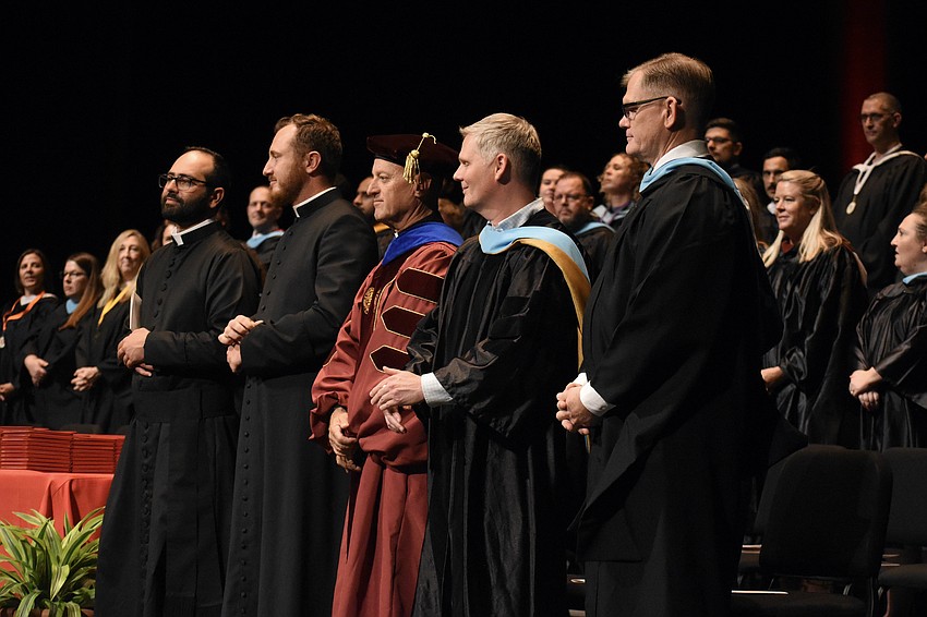 Assistant Chaplain Father Christian Chami, School Chaplain Father Alex Pince, Superintendent of Catholic education for the Diocese of Venice Rev. John Belmonte, Assistant Principal for Curriculum Matthew Ittig and Principal Ben Hopper stand as the ceremony begins.