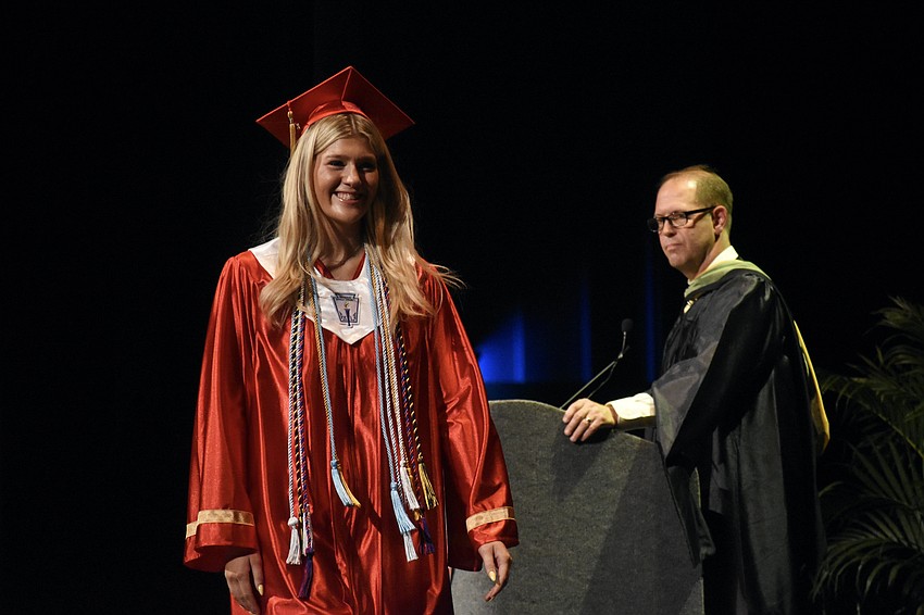 Carlyn Collison walks the stage past Assistant Principal Stefan Gates.