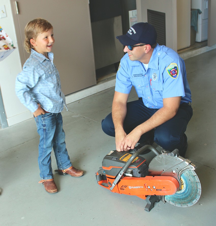Harry Noordzy is shown firefighting equipment by James Bacigalupi, who helped give birth to him.