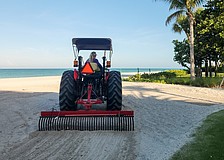 Angie Cupp uses a tractor and landscaping rake attachment to clean Longboat Key beaches of debris.