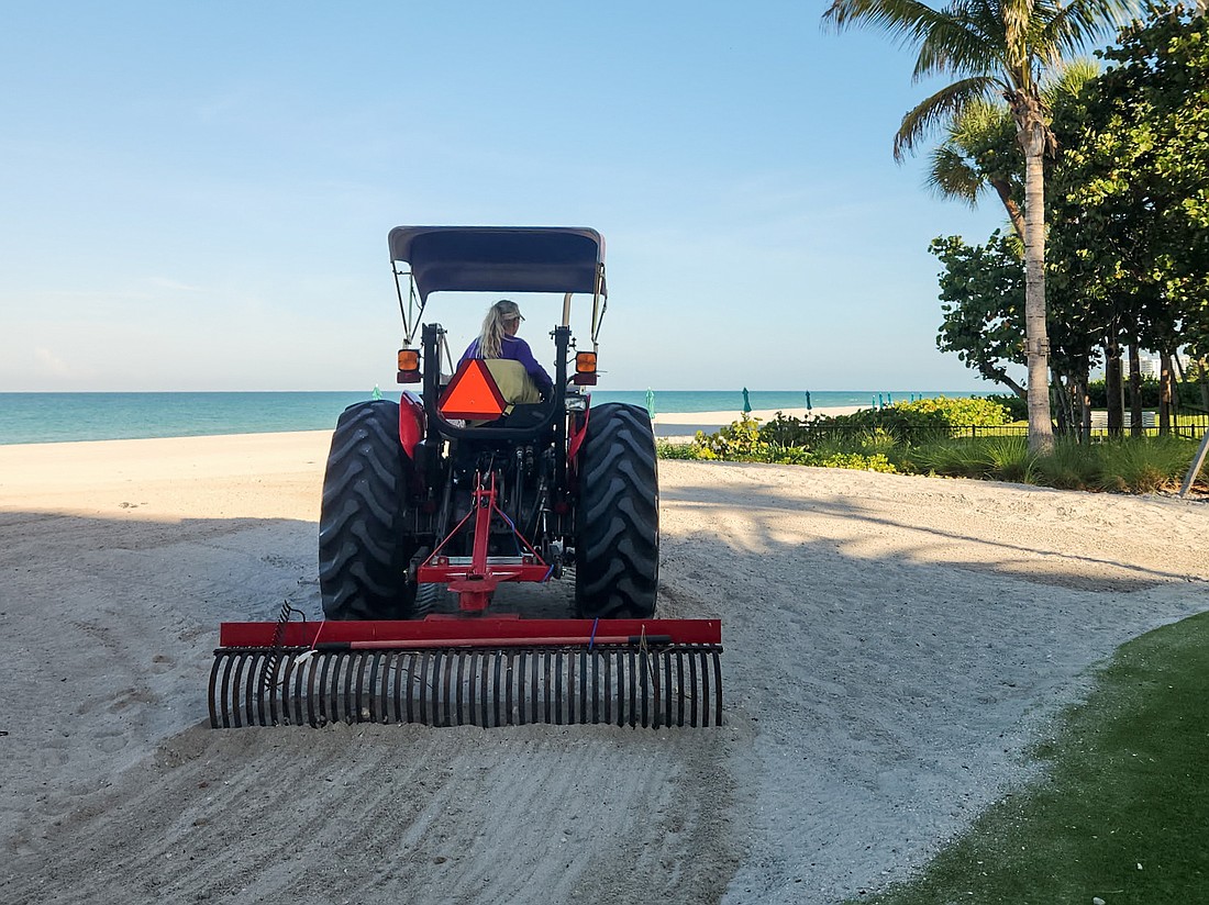 Angie Cupp uses a tractor and landscaping rake attachment to clean Longboat Key beaches of debris.