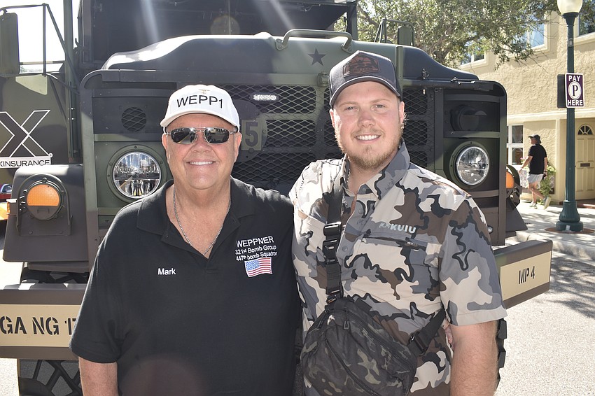 Mark Weppner and his son Nick Weppner of Florida Military Vehicle Heritage Group prepare for the parade with their M923 military vehicle. They hope to honor their father and grandfather Gene Wepper who earned a purple heart in World War II.