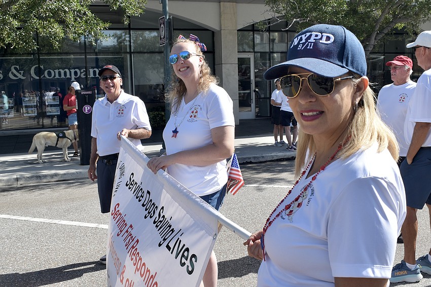 Co-founder Paul Johnson, Alyssa Bates and Yvette Ortiz of Service Dogs Saving Lives prepare to walk in the parade.