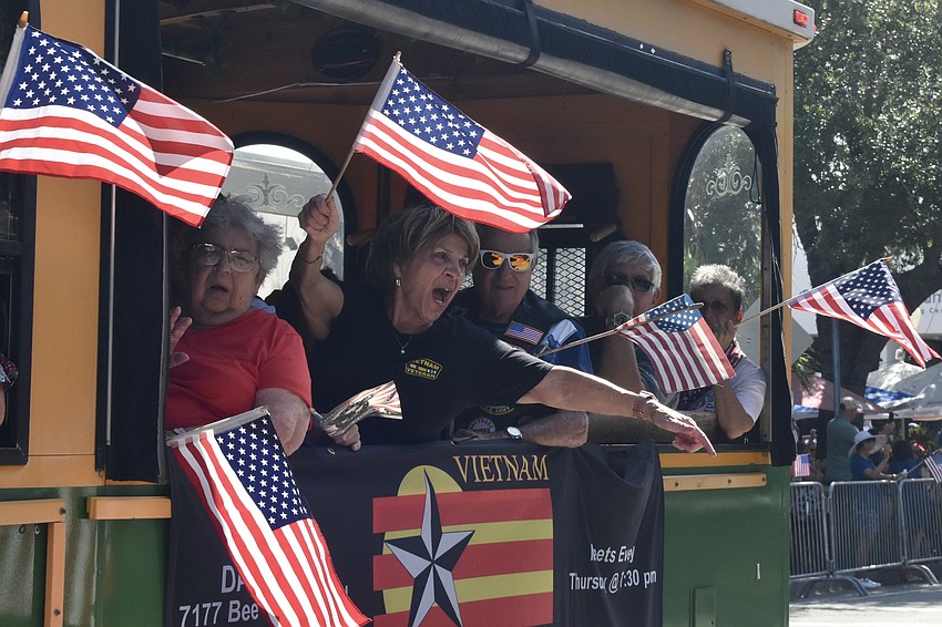 Members of the Vietnam Brotherhood wave from a trolley.