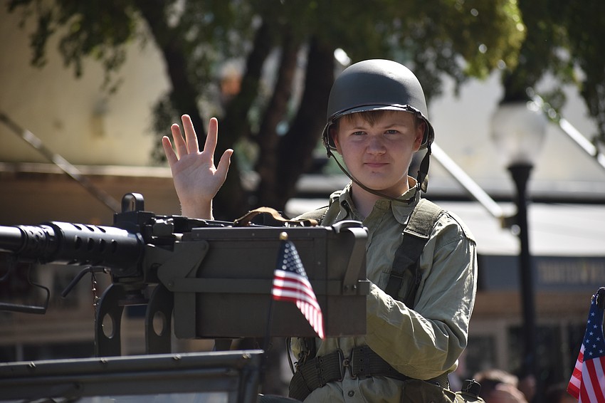 Ethan Parker, 14, with Florida Military Vehicle Heritage Group, waves to paradegoers.