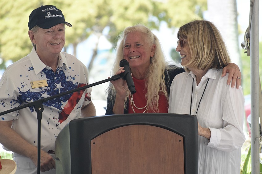 Sarasota County Commissioner Mark Smith and Jan Solomon welcome Sally Reed, co-founder of Key Sailing with her late husband Tom Reed, to the stage.