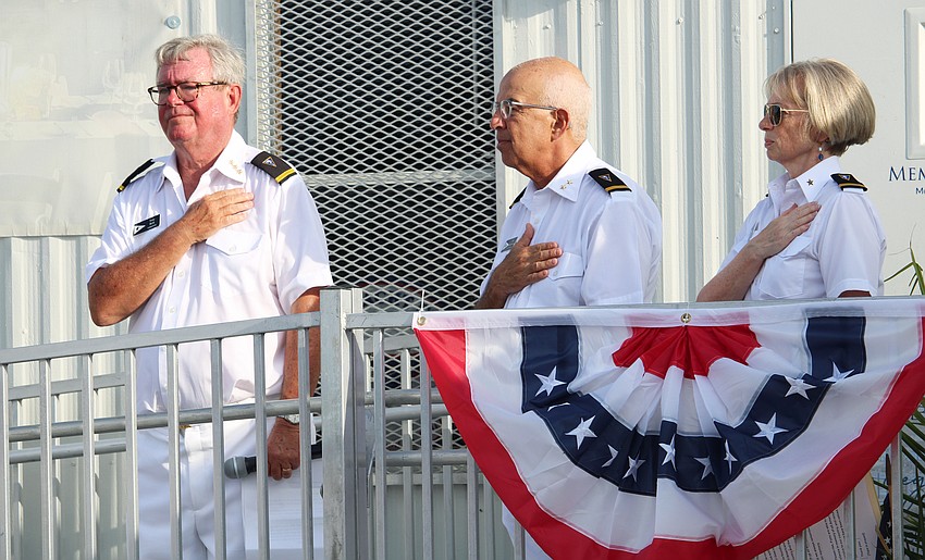 Bird Key Yacht Club Commodore Tony Britt, Vice Commodore Saul Landesberg and Rear Commodore Lynne Pettigrew hold their hands over their hearts during the national anthem.