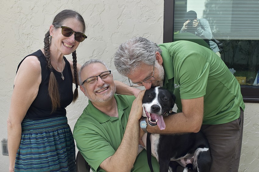 Rabbi Elaine Glickman, Rabbi Michael Shefrin, and Rabbi Brenner Glickman bless the Glickmans' dog Ellie.