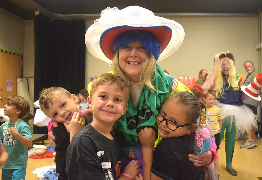 Kindergarten students Jackson Huber, Weston Whalen and Melody Meza-Garcia are responsible for dressing Media Specialist Elizabeth Harris as crazy as possible.