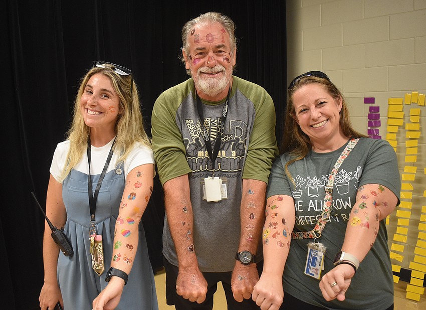 Kindergarten Teacher Allie Sullivan, PE Coach Joe Szewczyk and Math Teacher Melissa Spencer are all tatted up to represent the student growth in English language.