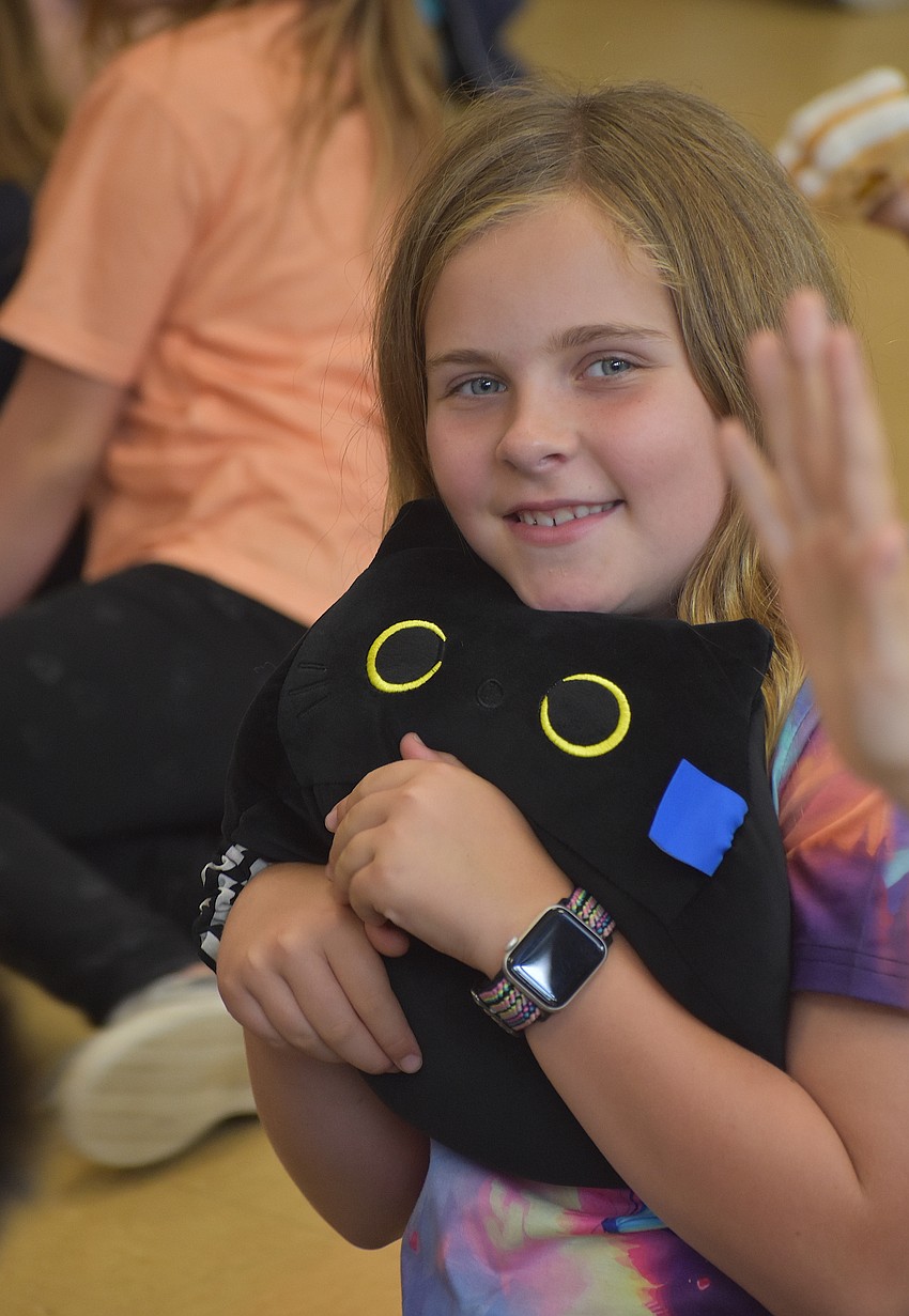 Penny Seguin, a third grader at Myakka City Elementary, is excited to take home a stuffed cat as a prize because most cats are cuddly and nice.