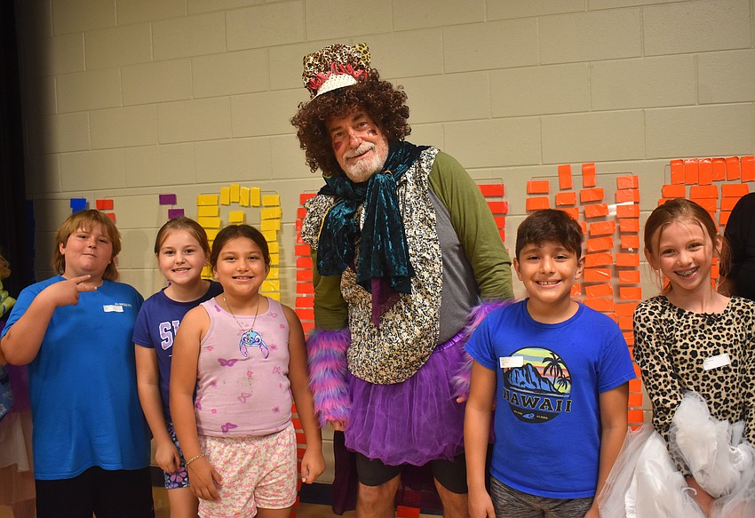 Third grade students Winston Walauskis, Braelyn Rhodes, Abygail Rincon-Garcia, PE Coach Joe Szewczyk, Luis Posso and Novalee Roberts prepare to reveal their outfit to the crowd during the Tacky Fashion Show.