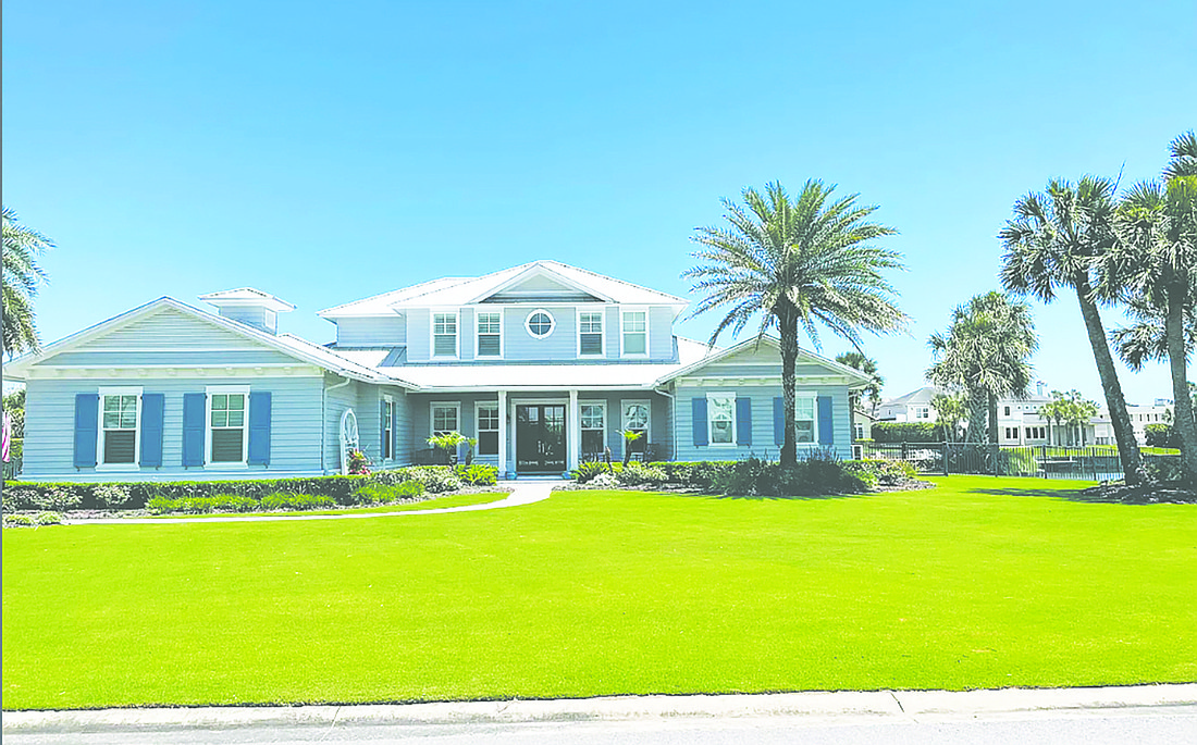 This waterfront two-story home features five bedrooms, four full and one half-bathrooms, a guest suite, porches, a patio, pool, putting green and three-car garage.